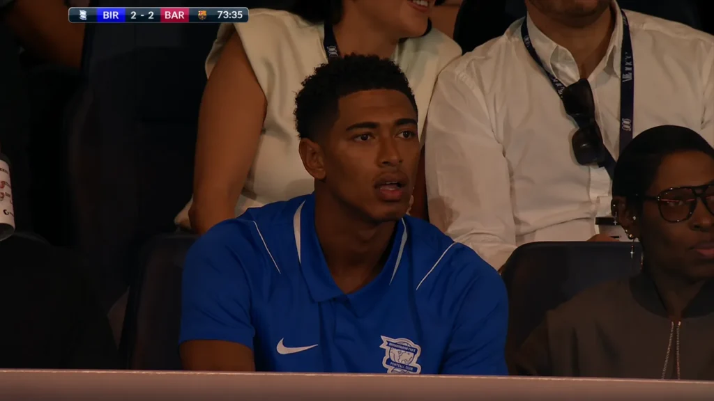 Jude Bellingham watches Birmingham City's preseason friendly against Barcelona from the stands at St. Andrew's, wearing a Birmingham City shirt in support of his boyhood club.