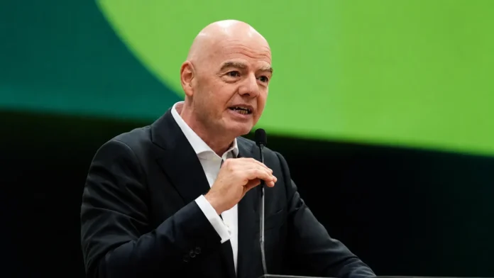 Gianni Infantino speaking into a microphone amid growing FIFA leadership crisis
